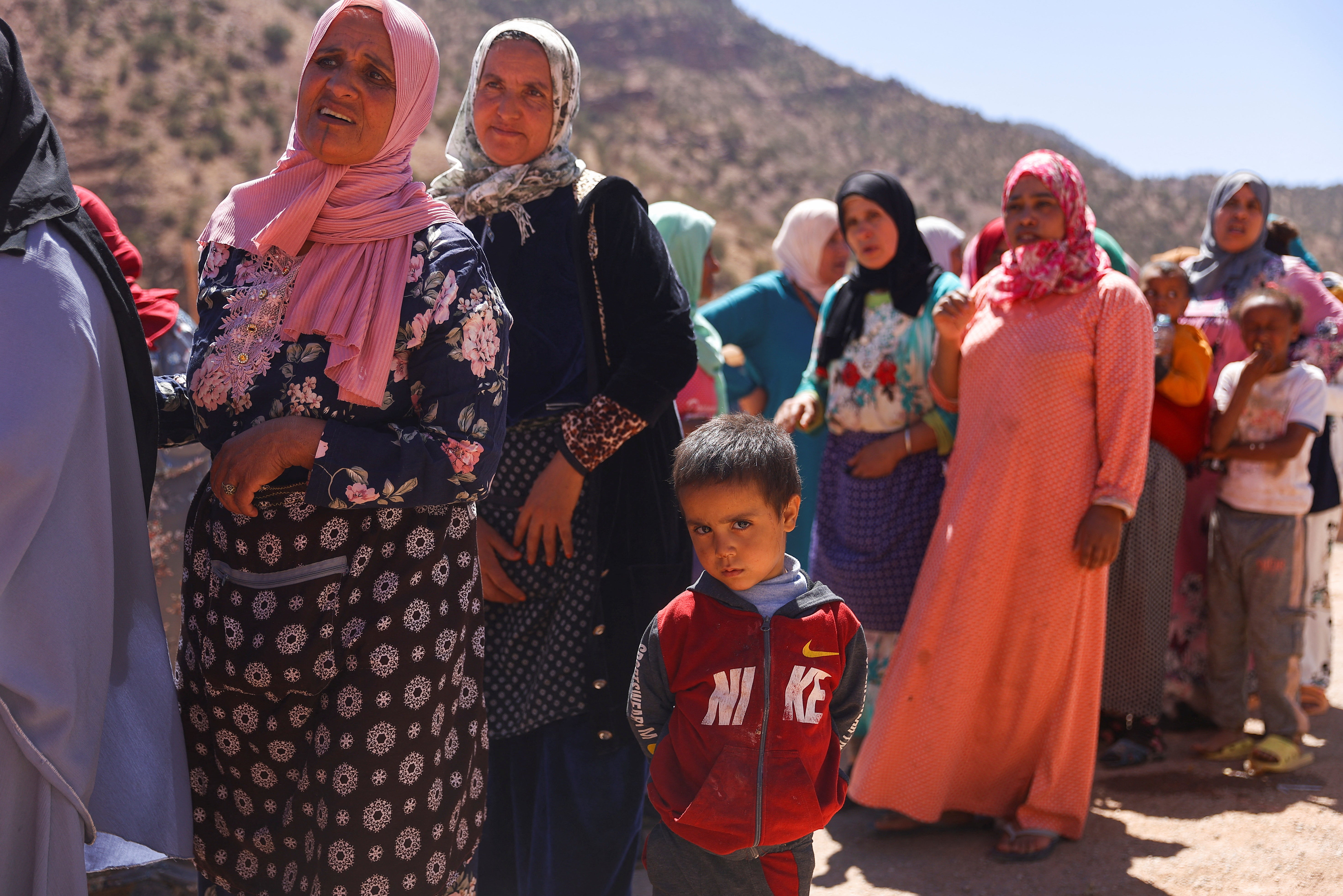 Women and children queue for aid in Tinmel in the aftermath of a deadly earthquake