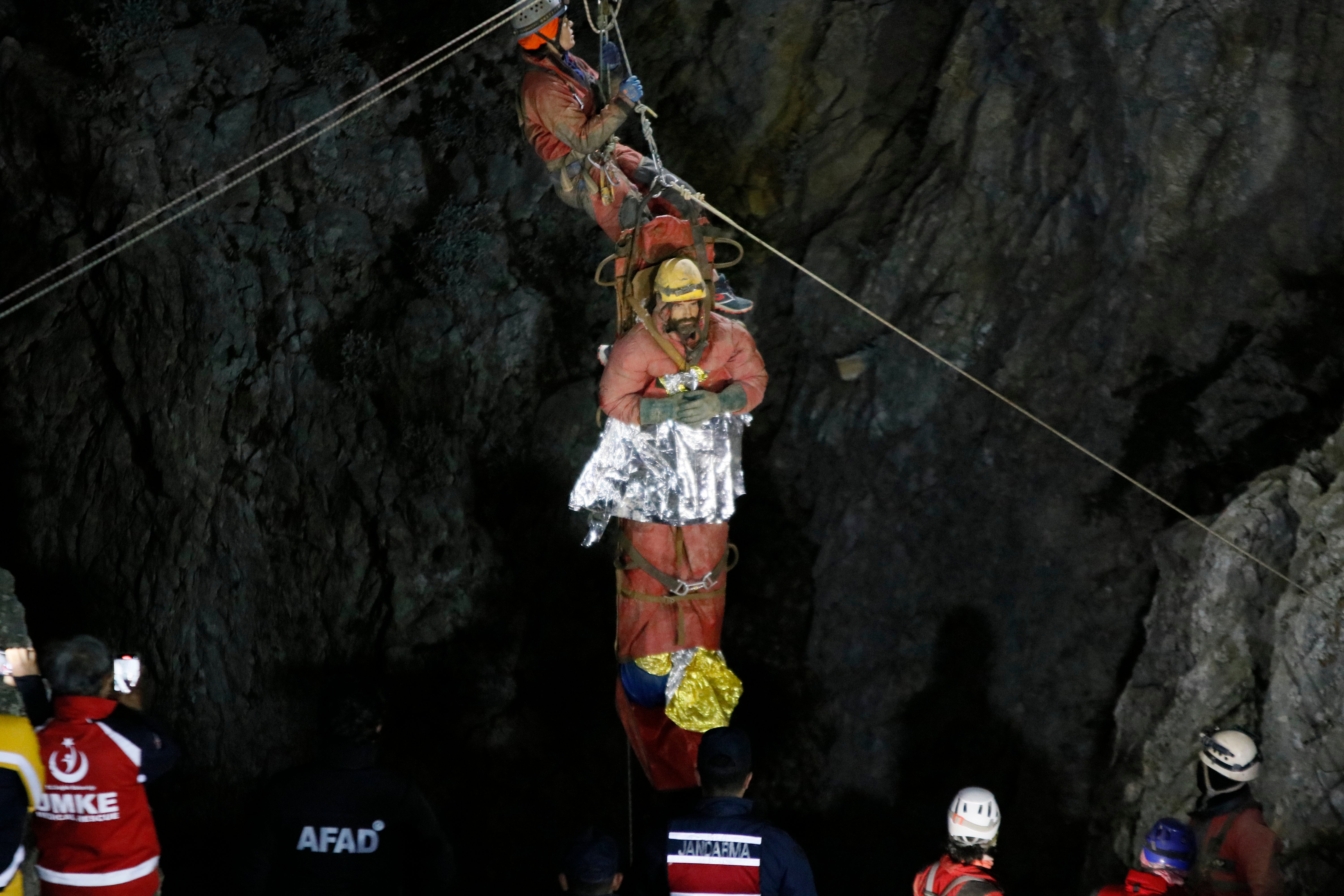 Dickey being hoisted towards the mouth of the cave