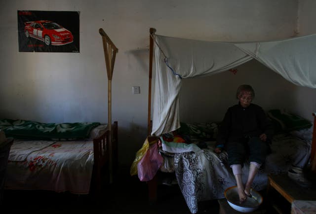 <p>A senior woman washes her feet as she sits on her bed at the Happy Times Nursing Home on December 12, 2007 in Kunming of Yunnan Province, China</p>