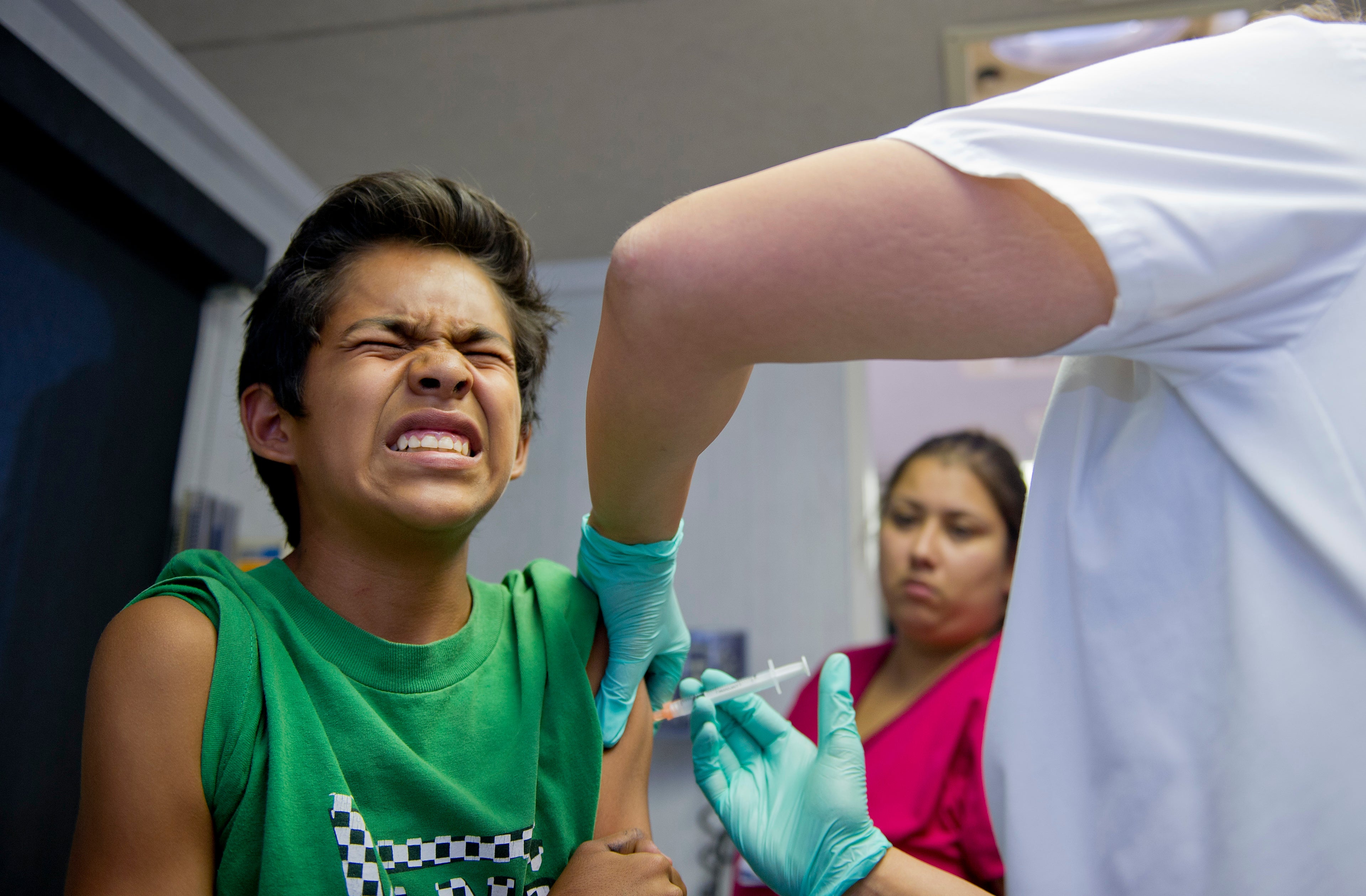 <p>File Public school student Julio Valenzuela, 11, grimaces as he gets a vaccination at a free immunization clinic for students before the start of the school year</p>