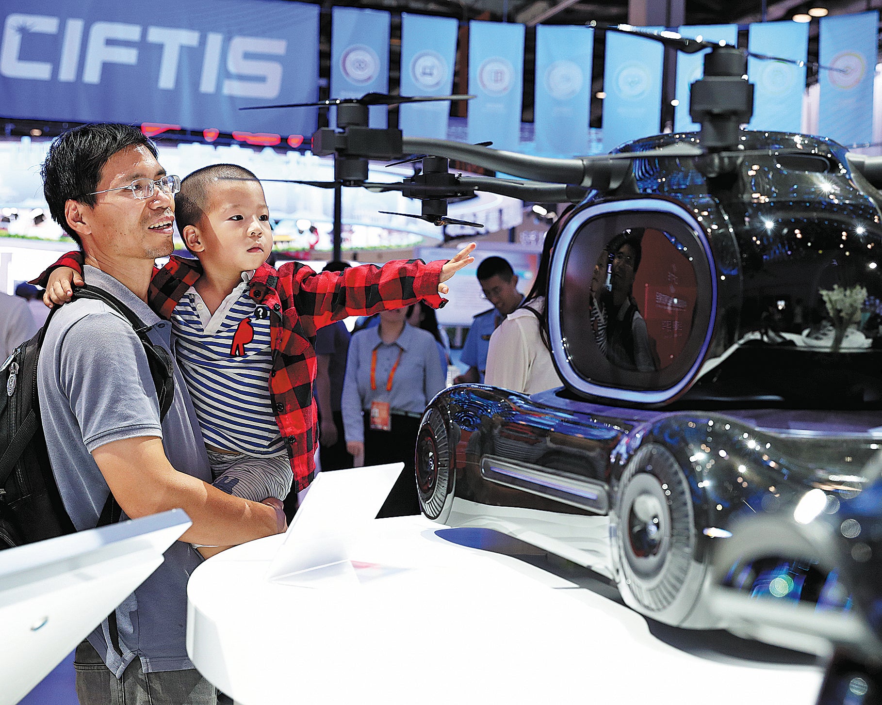 Visitors check out a miniature flying vehicle during the 2023 China International Fair for Trade in Services in Beijing on 3 September, 2023