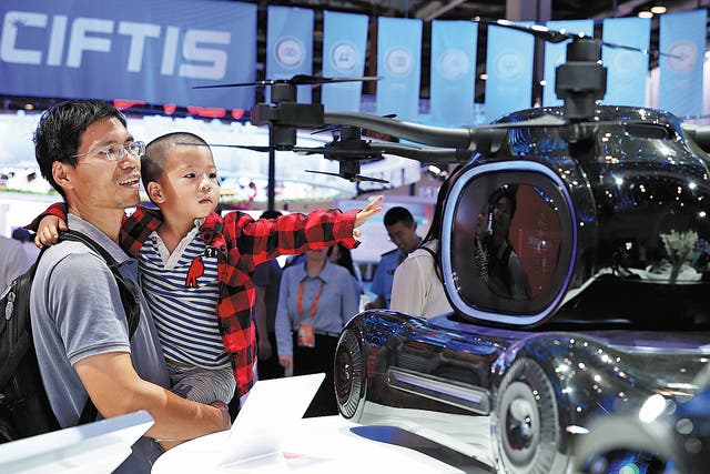<p>Visitors check out a miniature flying vehicle during the 2023 China International Fair for Trade in Services in Beijing on 3 September, 2023 </p>
