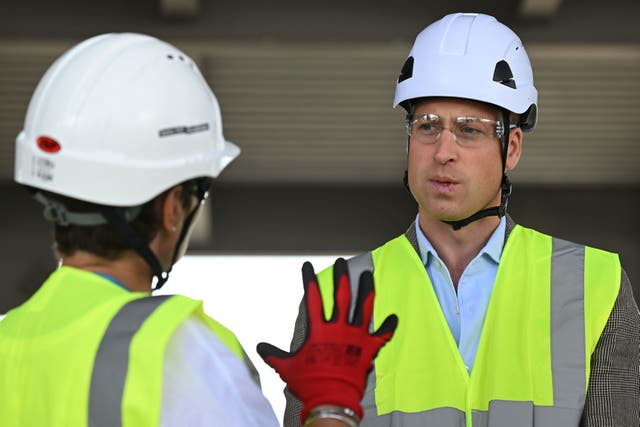 The Prince of Wales, wearing PPE including a hard hat and safety glasses, talks with workers from across the construction industry during a visit to a construction site in west London (Justin Tallis/PA)