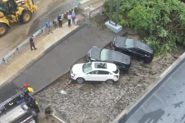 <p>A trio of cars caught on the edge of a sinkhole that opened up in Leominster, Massachusetts after heavy rains</p>