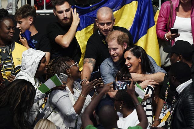 The Duke and Duchess of Sussex hug as they finish watching the sitting volleyball competition (Jordan Pettitt/PA)