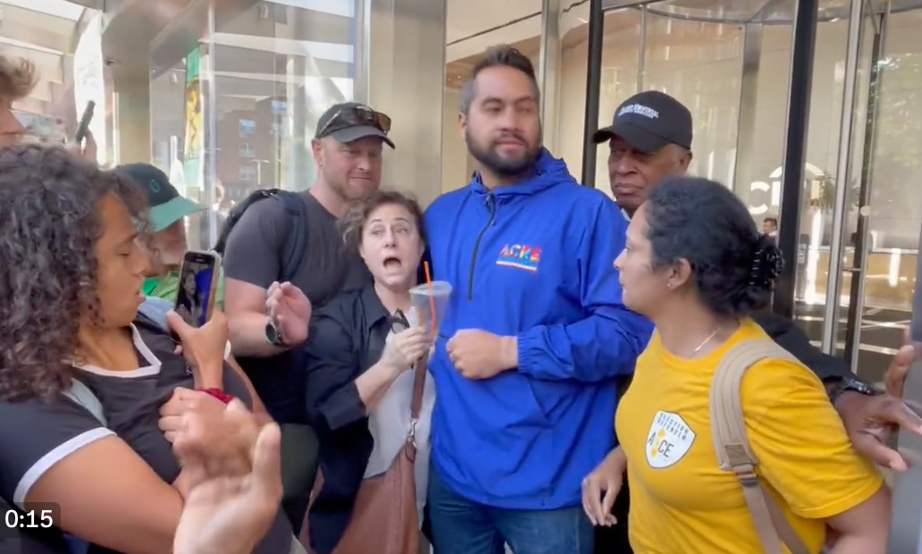 A woman tried repeatedly to bypass protesters before being led away by security