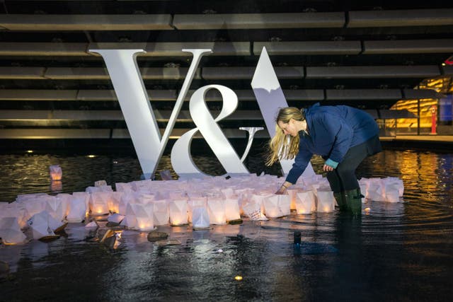 Artist Kate Colin with hundreds of ‘birthday wishes’ floating on the water pools outside V&A Dundee (Jane Barlow/PA)