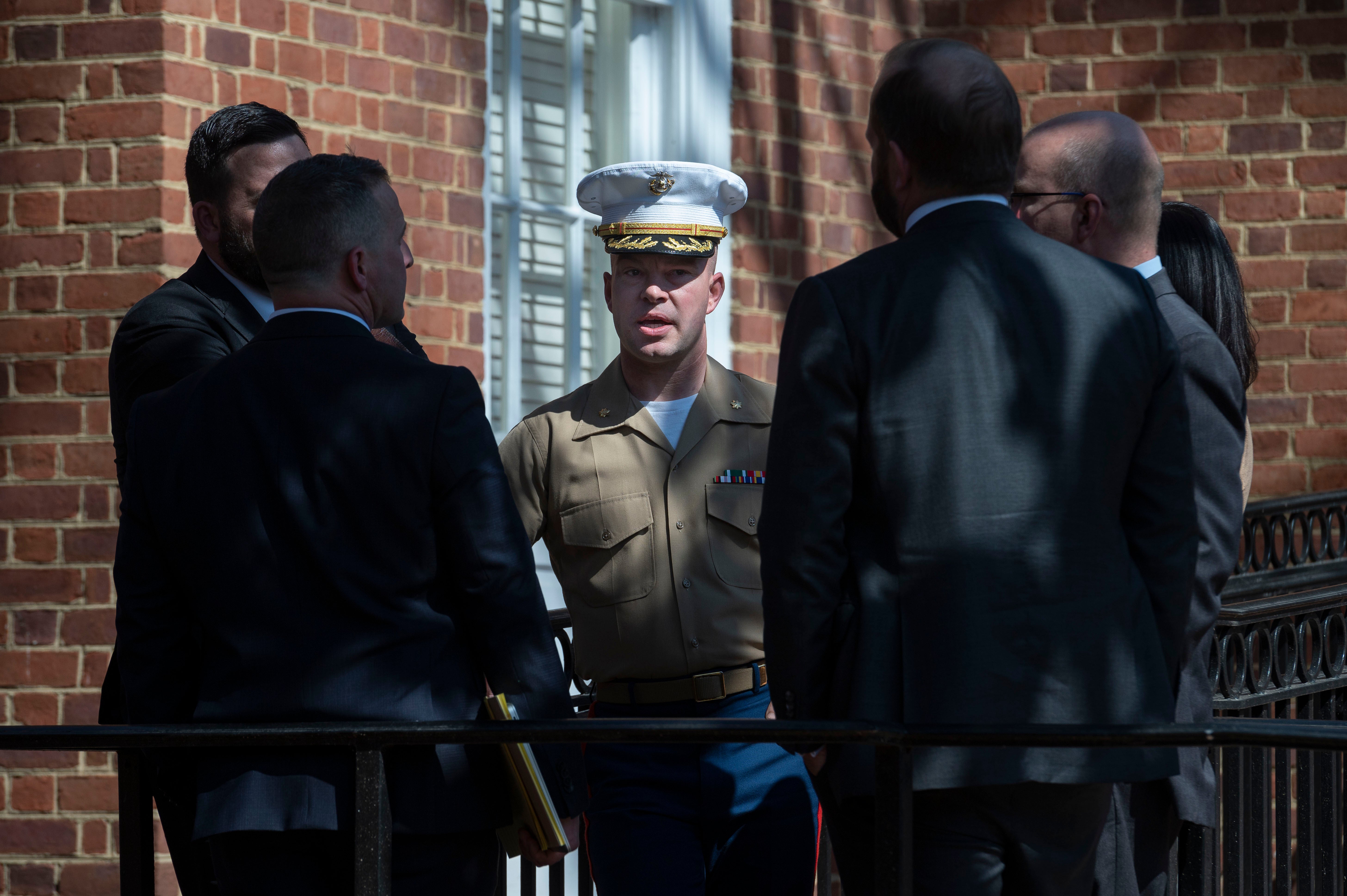 US Marine Corp Major Joshua Mast, center, talks with his attorneys