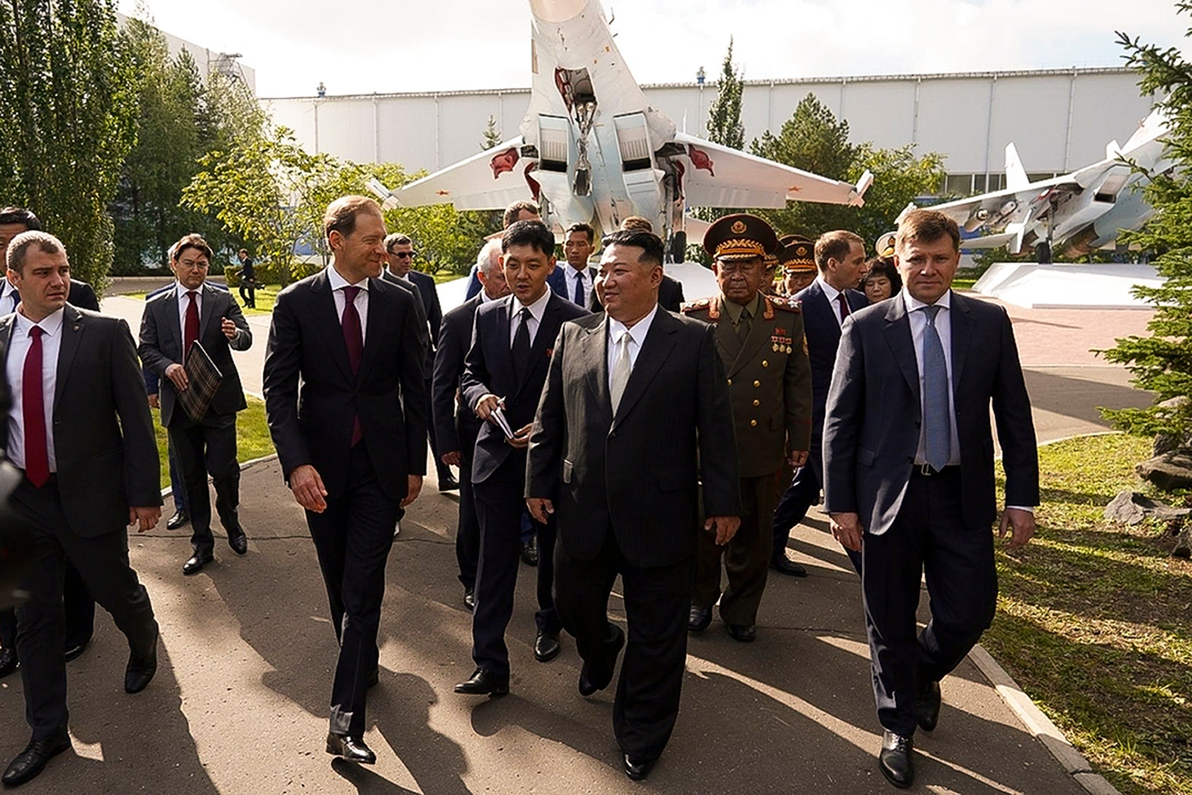 North Korean leader Kim Jong-un, center, listens to Deputy Prime Minister and Minister of Trade and Industry Denis Manturov, center left, while visiting a Russian aircraft plant that builds fighter jet