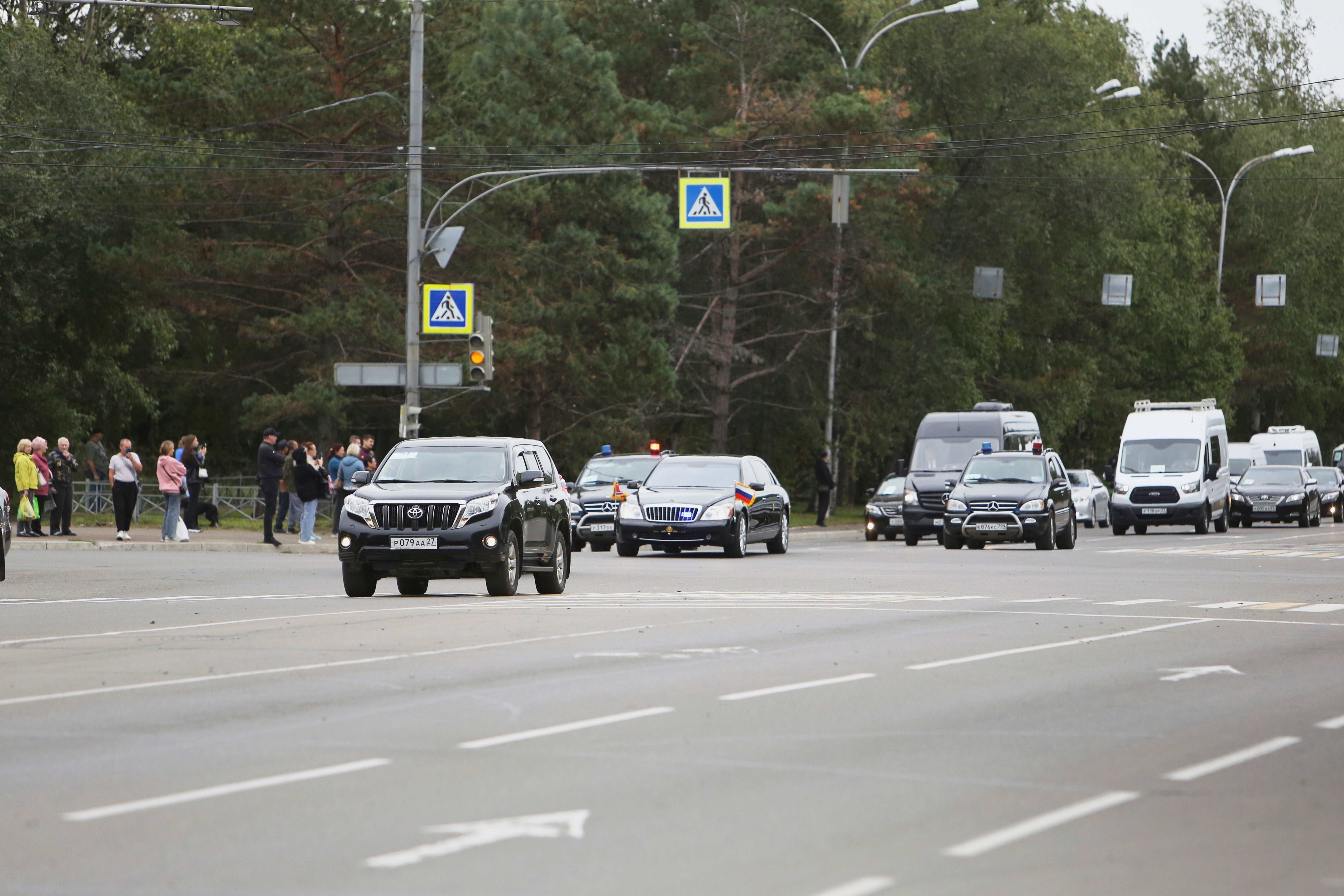 People look at the motorcade of North Korea's leader Kim Jong Un driving to the railway station prior to his departure from Komsomolsk-on-Amur