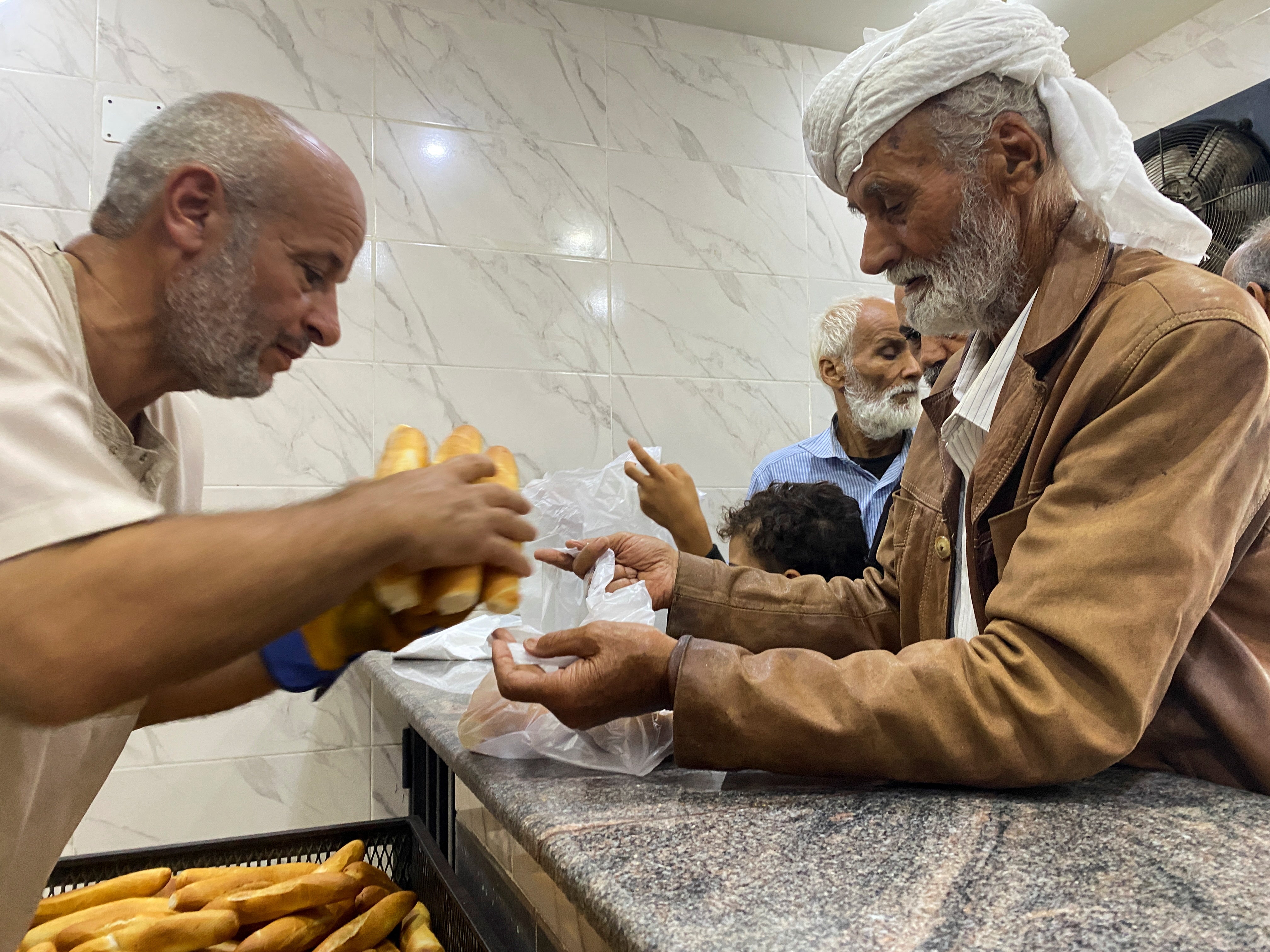 People get bread from a bakery, in the aftermath of the floods in Derna