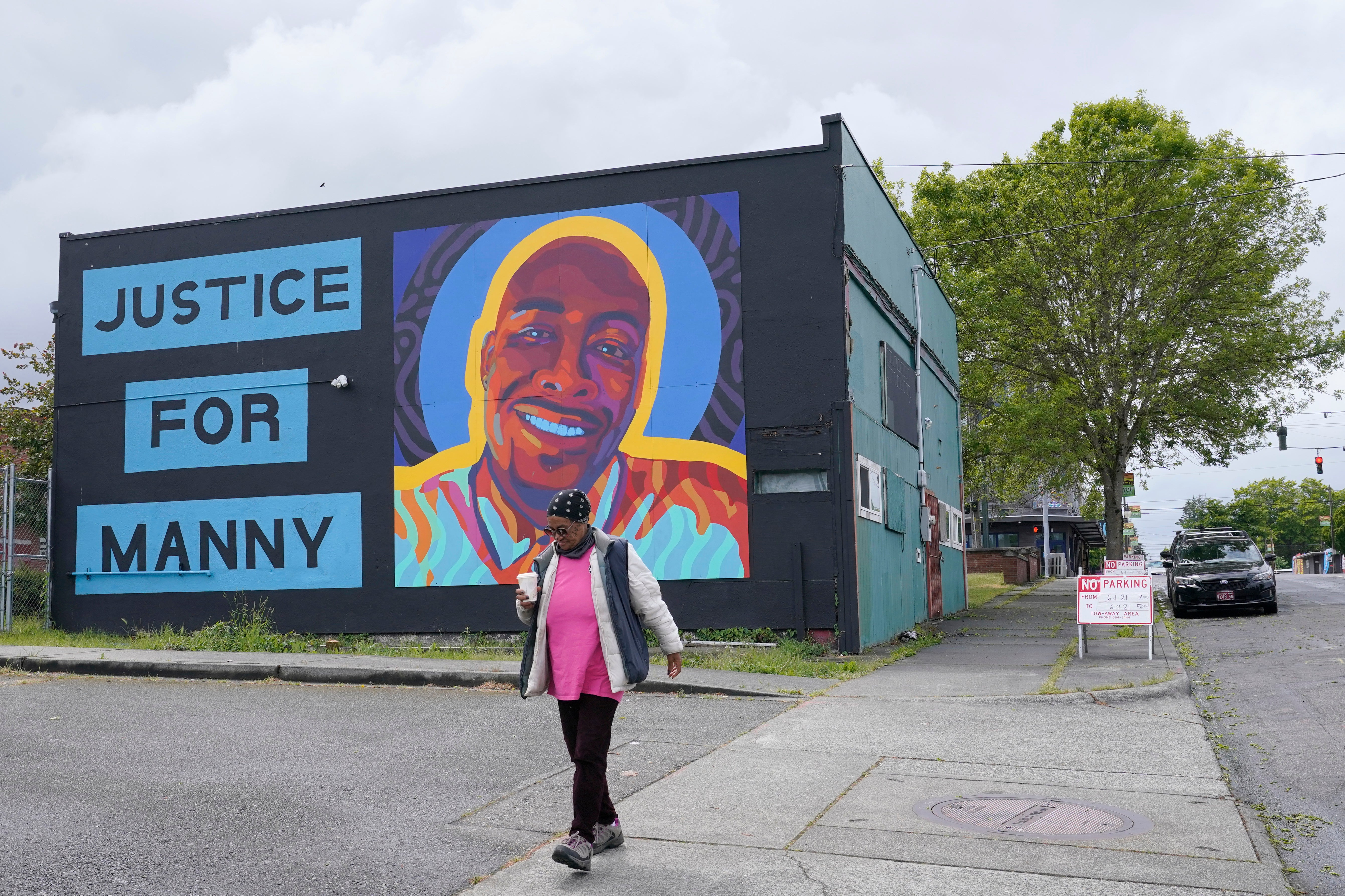 A woman walks past a mural honoring Ellis