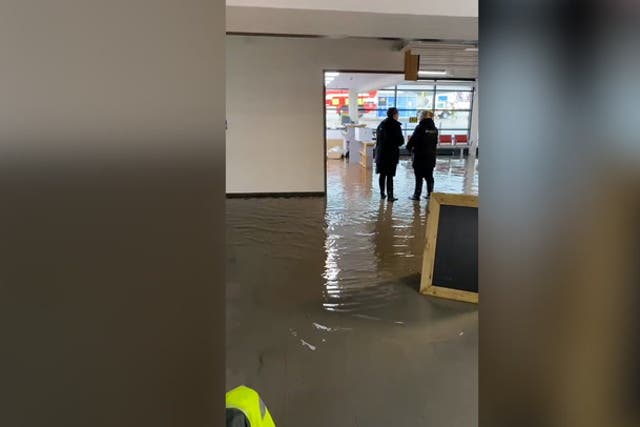 <p>Inside a flooded Exeter Airport as staff and passengers wade through water in terminal. </p>
