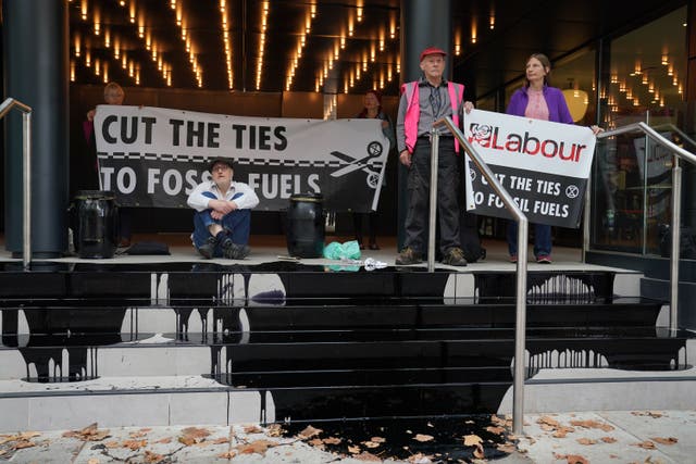 Extinction Rebellion have poured a pool of fake oil over the steps of the Labour Party’s London headquarters and let off smoke grenades (Lucy North/PA)