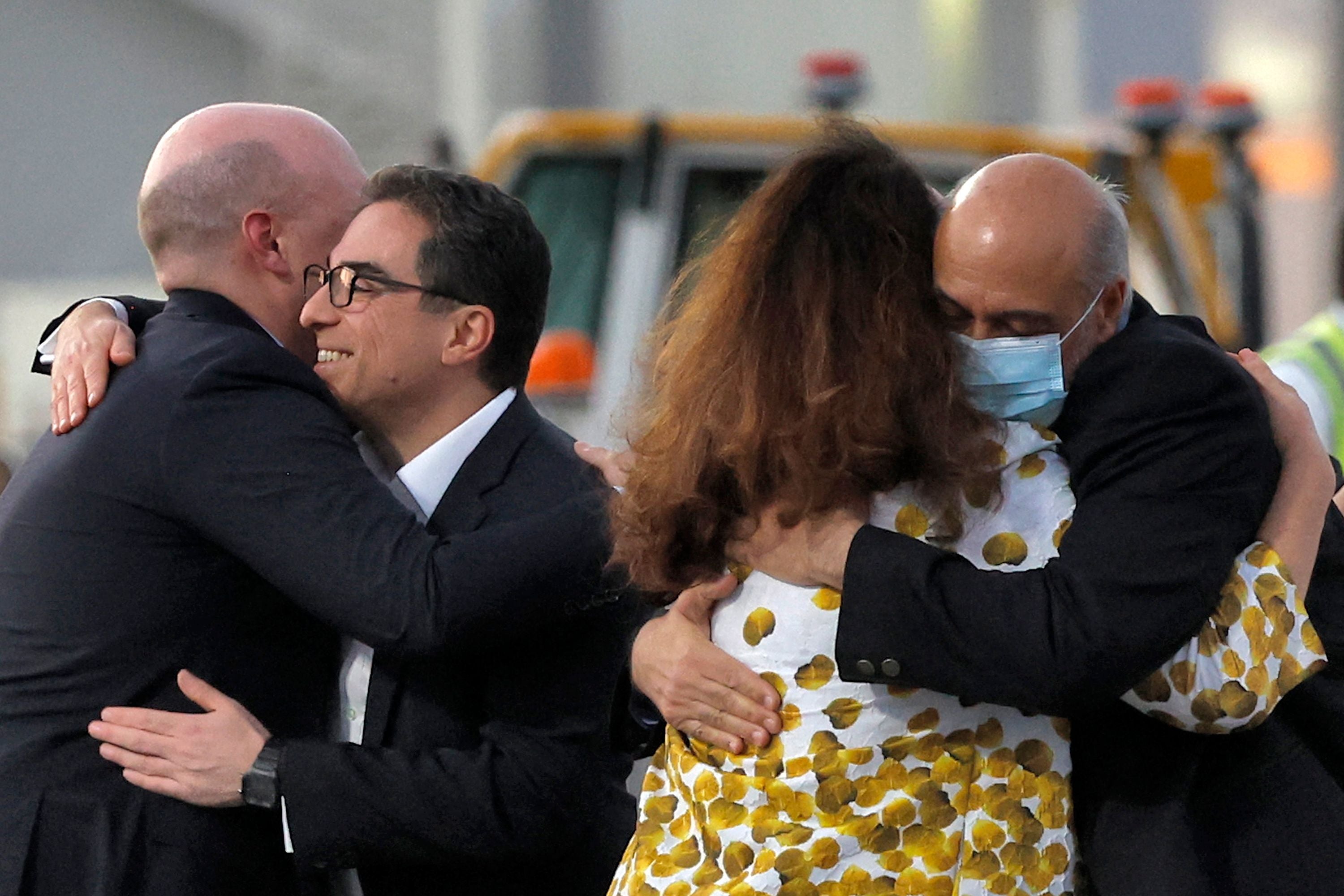 Mr Tahbaz (R, wearing mask) is welcomed on the tarmac at Doha airport after his release from Iran.