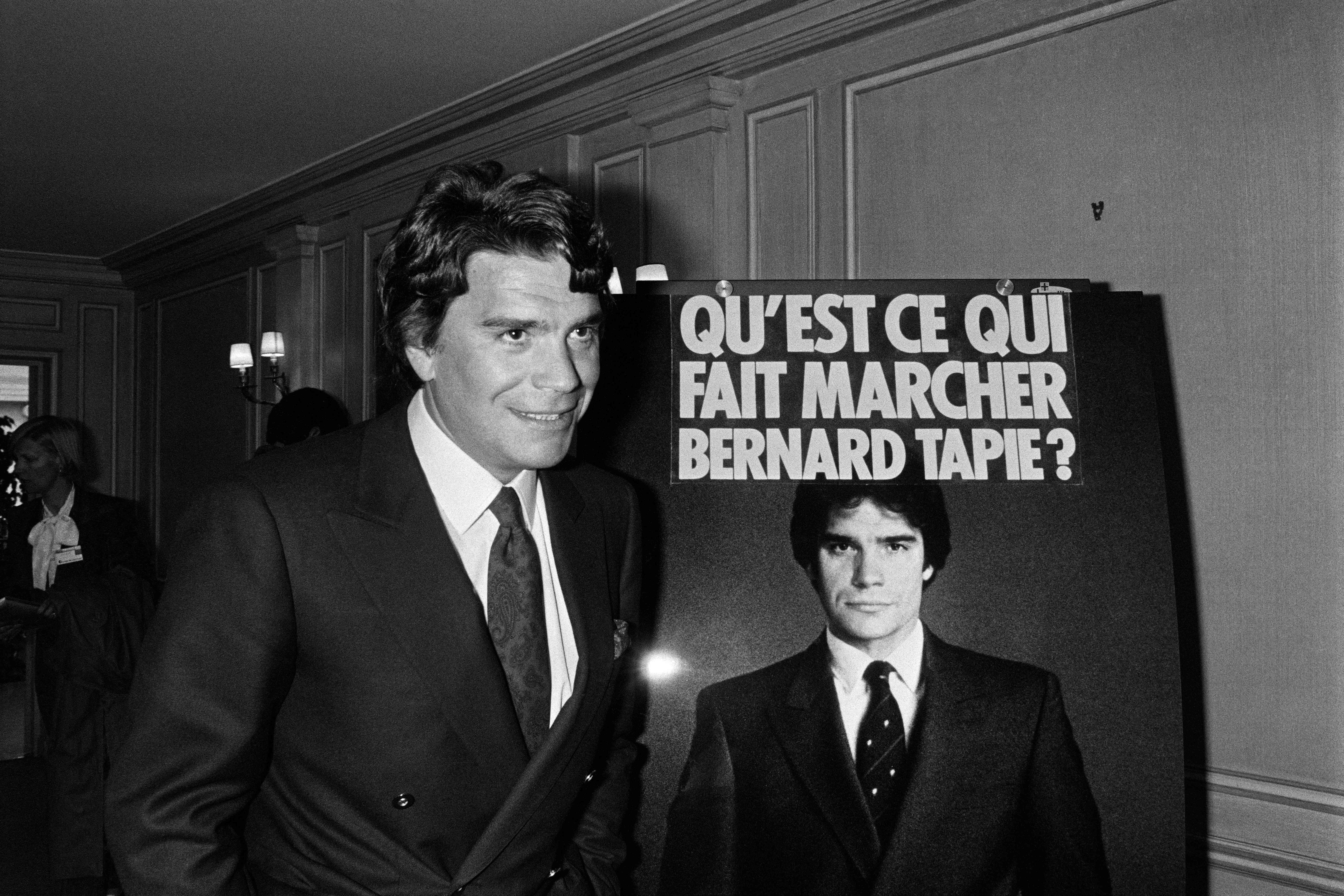 French businessman Bernard Tapie poses next to an advertising poster on 18 April 1986 in Paris