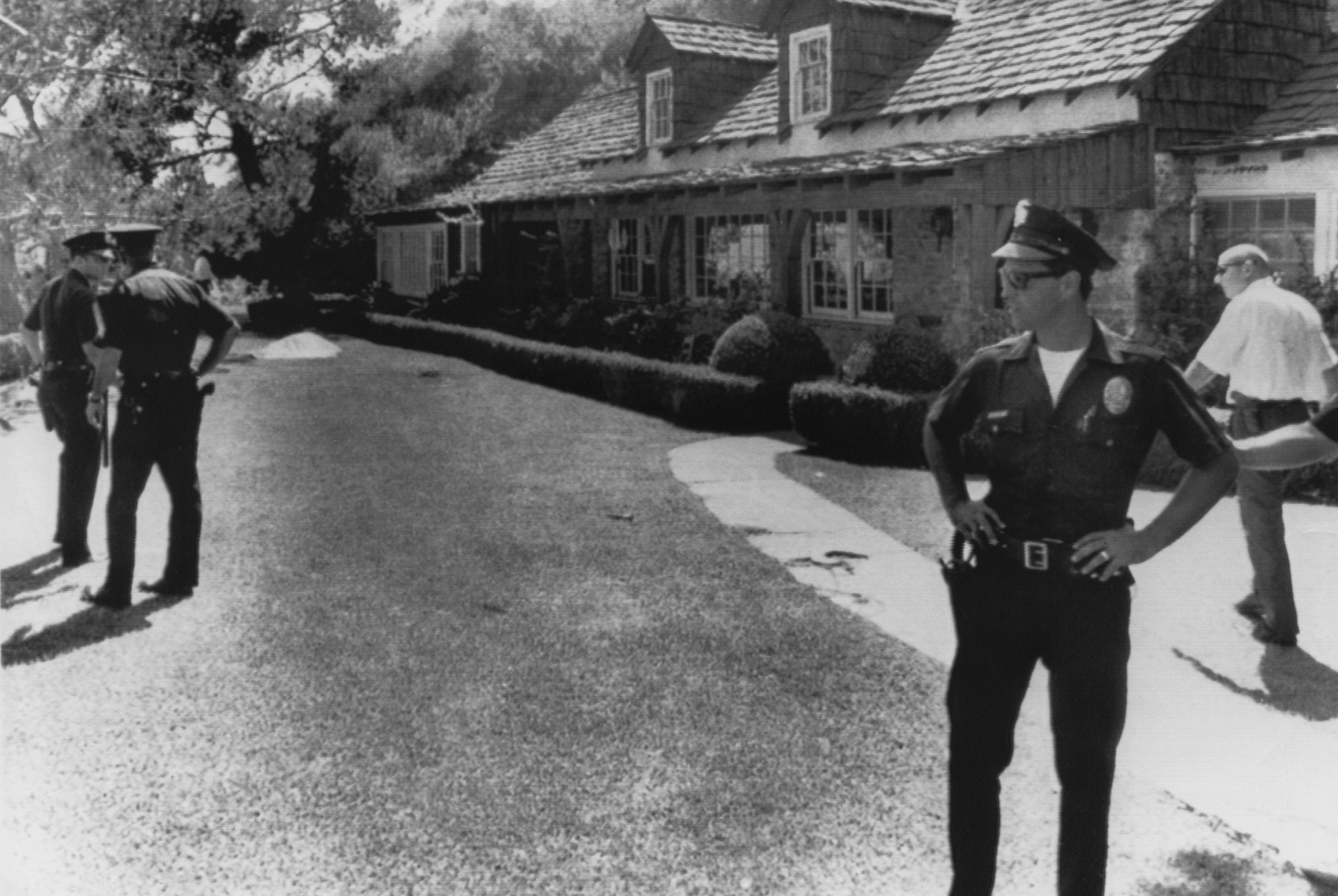 Police stand guard outside the home of film director Roman Polanski, following the murder of his wife Sharon Tate, and four other people by Charles Manson and his ‘family’ in 1969
