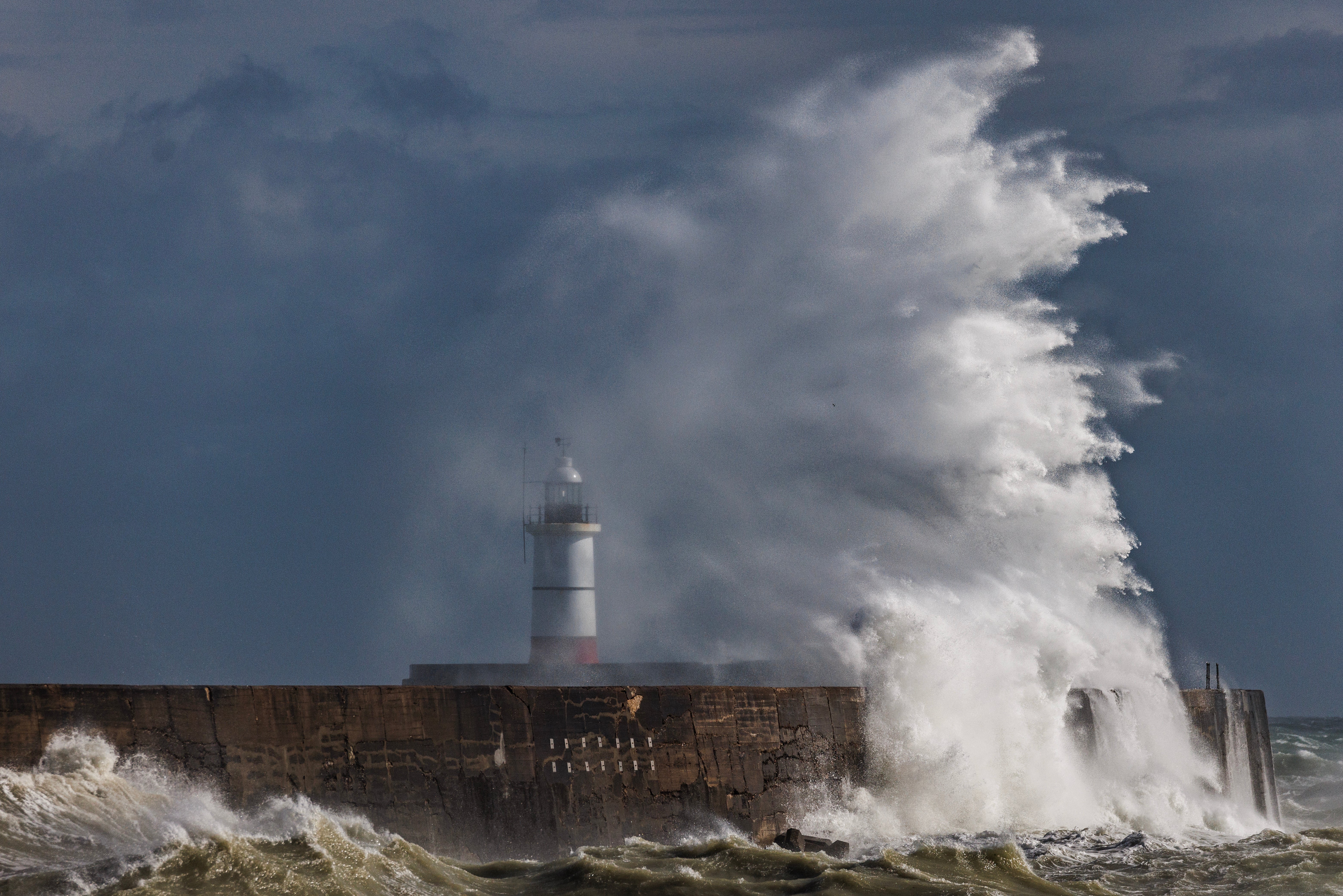 Storm waves batter the breakwater and lighthouse at Newhaven, East Sussex, on Monday
