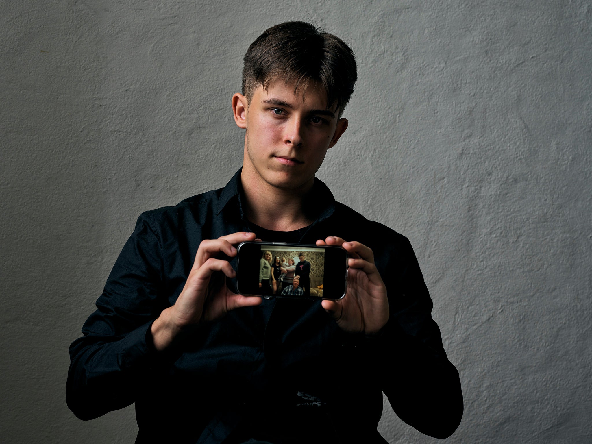 Igor, 18, from Mariupol in Ukraine, shows a photograph on his phone of his family, who are still stuck in the Russian-controlled city