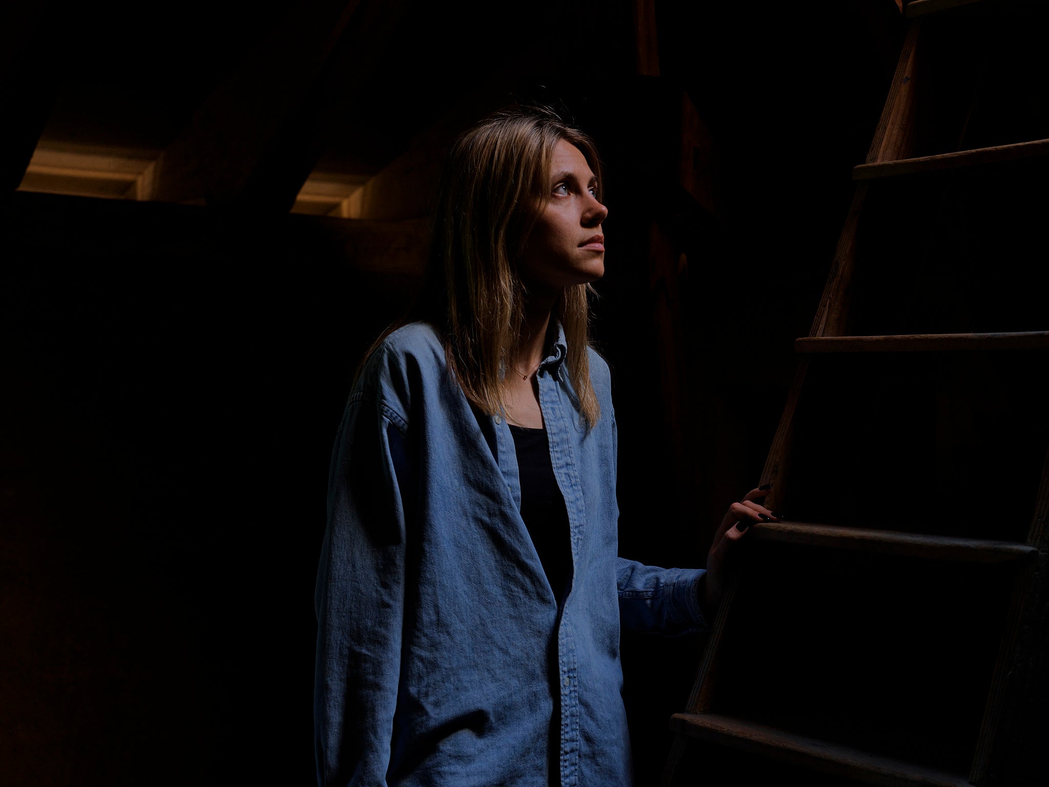 Hana, 28, from Odesa, looks through a window in the attic of Kloster Menzingen