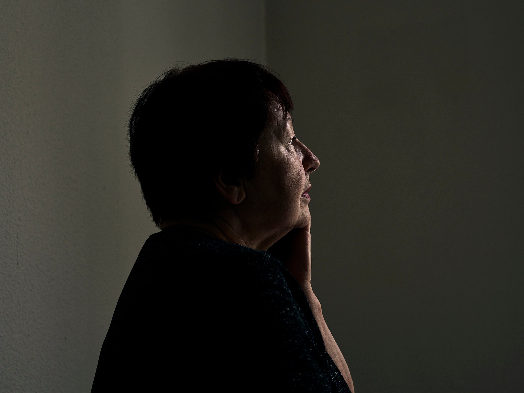 Olga, 67, looks out of a bedroom window to the courtyard below at Kloster Menzingen