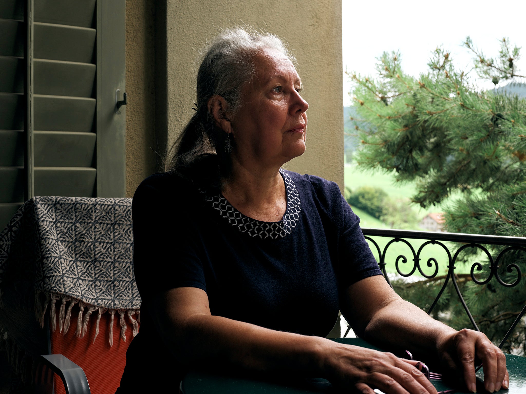 Tatiana, 65, from Kharkiv in Ukraine, looks out over the monastery grounds from a veranda