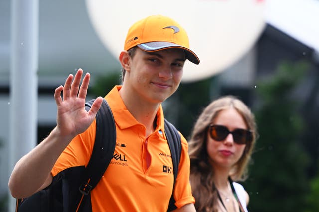 <p>Oscar Piastri waves to fans arriving at the Singapore Grand Prix</p>