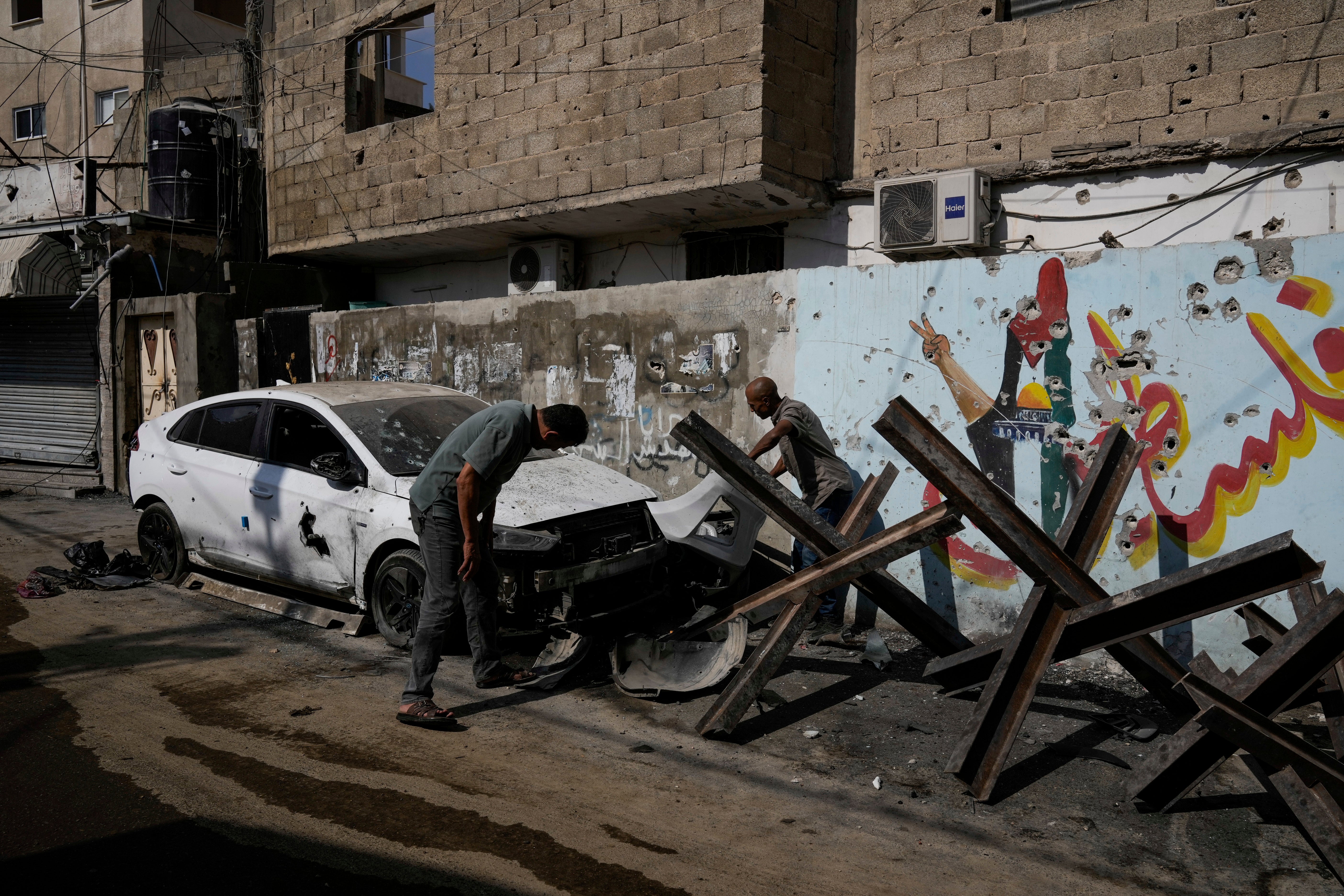 Palestinians inspect the damage after an Israeli military raid in the Jenin refugee camp