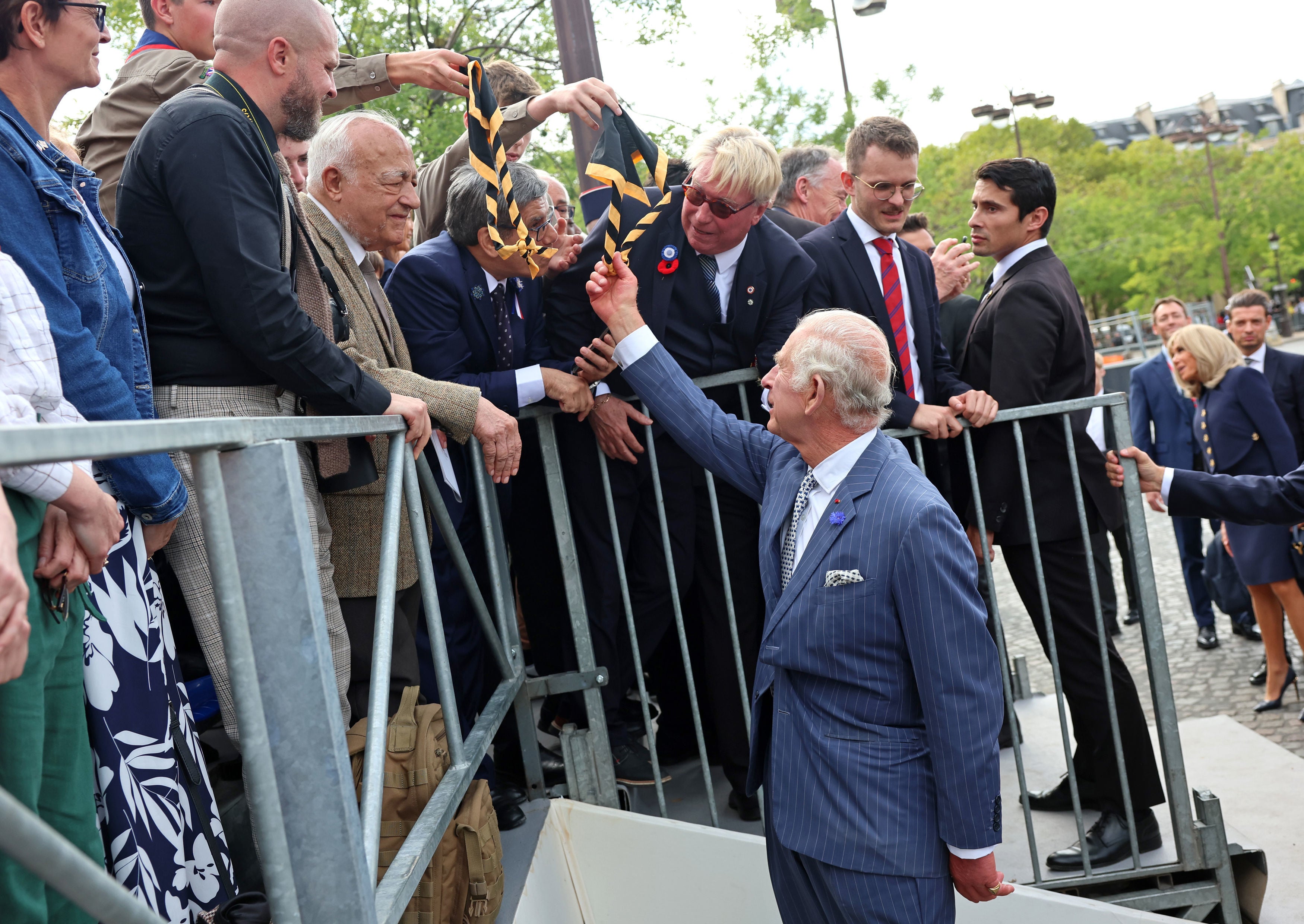 King Charles III shakes hands with representatives of local veteran organisations, scout and guide organisations, and the British School of Paris during a ceremonial welcome at the Arc de Triomphe