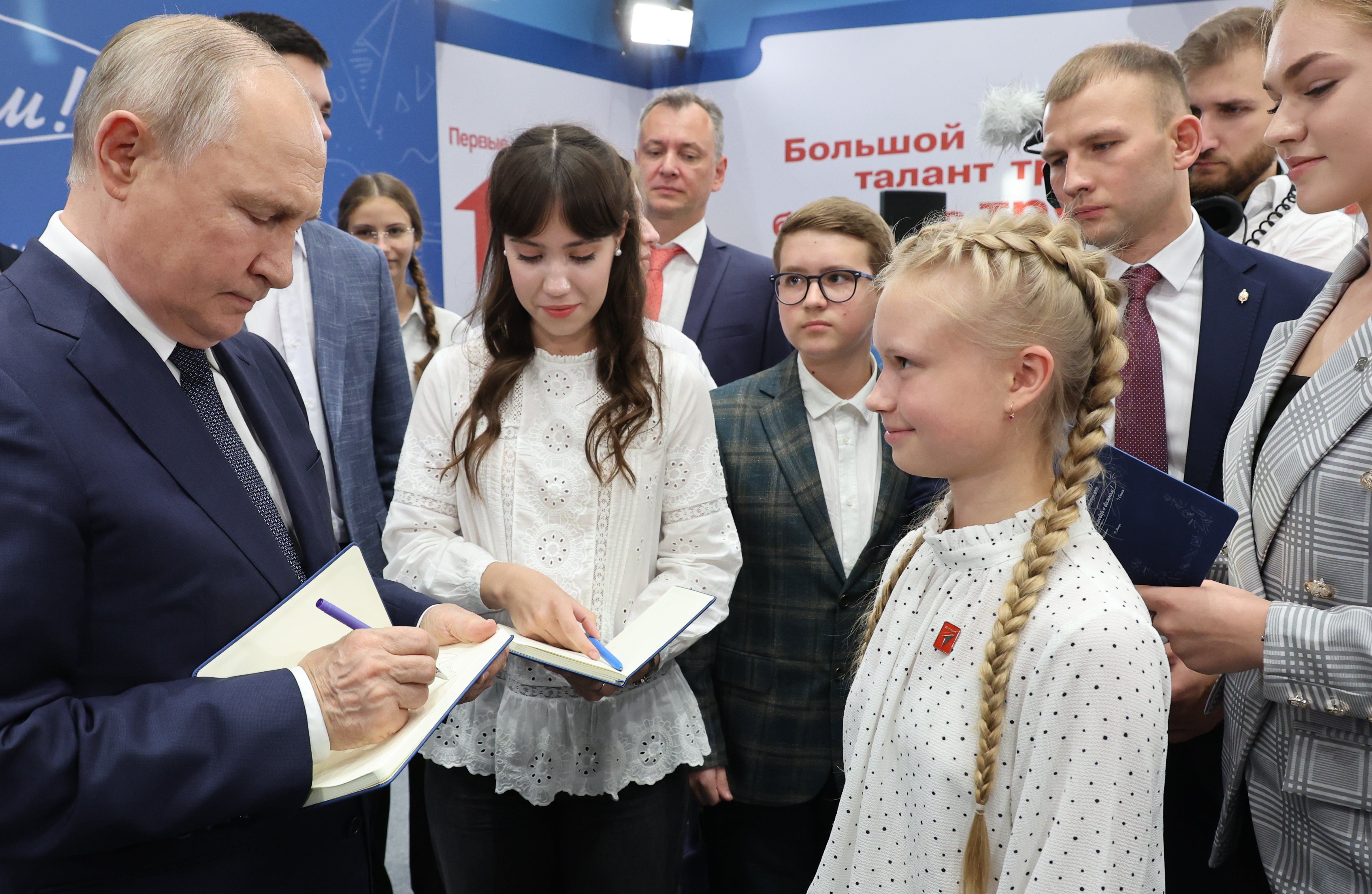 Russian president Vladimir Putin signs autographs for schoolchildren earlier this month