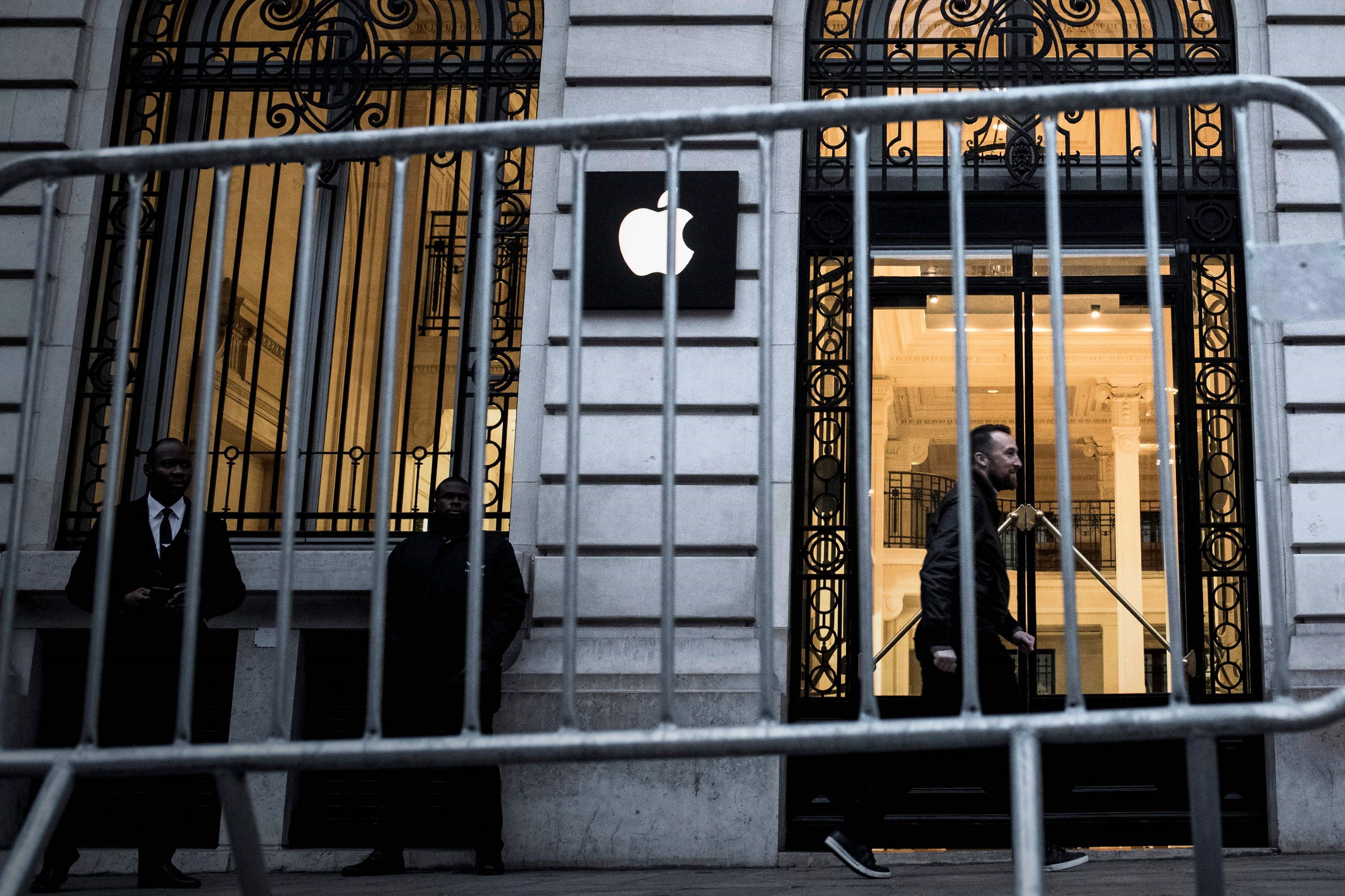 An Apple employee walks past an Apple shop in Paris on 3 November, 2017