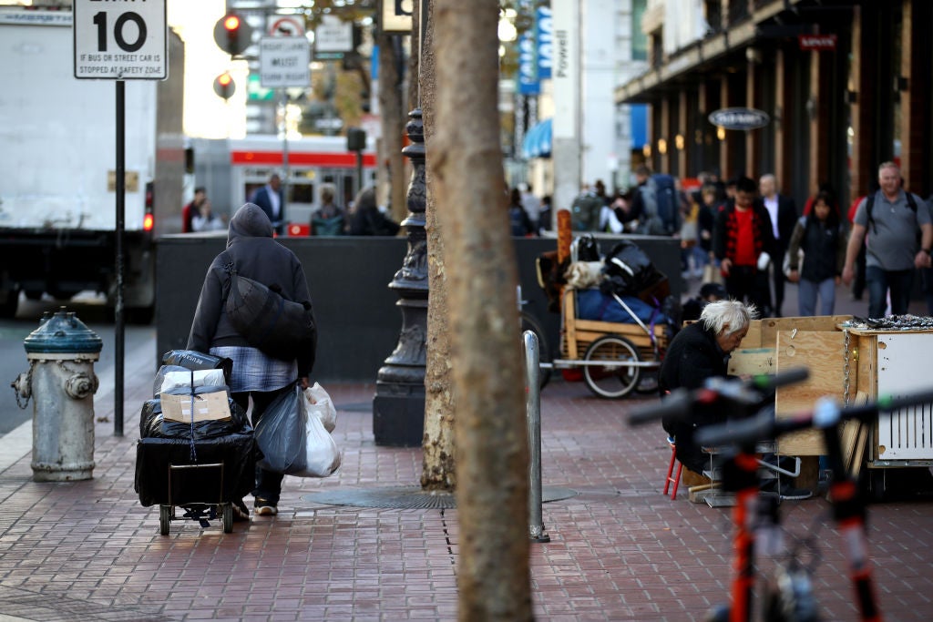 A homeless man pulls a cart with his belongings on 25 November 2019 in San Francisco, California