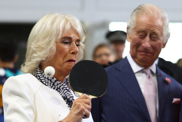 The Queen plays table tennis next to the King (Hannah McKay/PA)