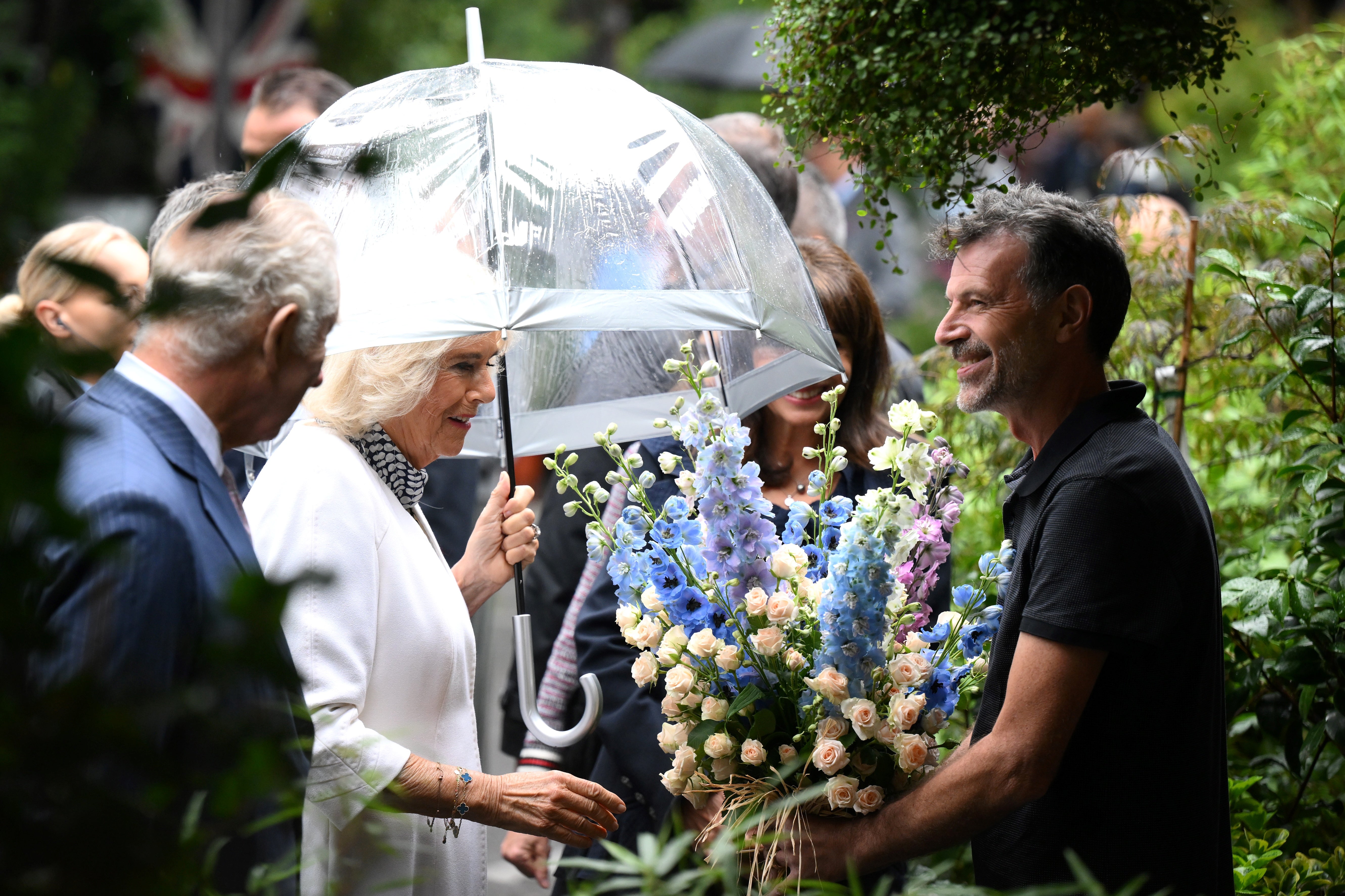 Charles and Camilla receive a gift during a visit to the central Paris Flower Market on day two of the state visit to France