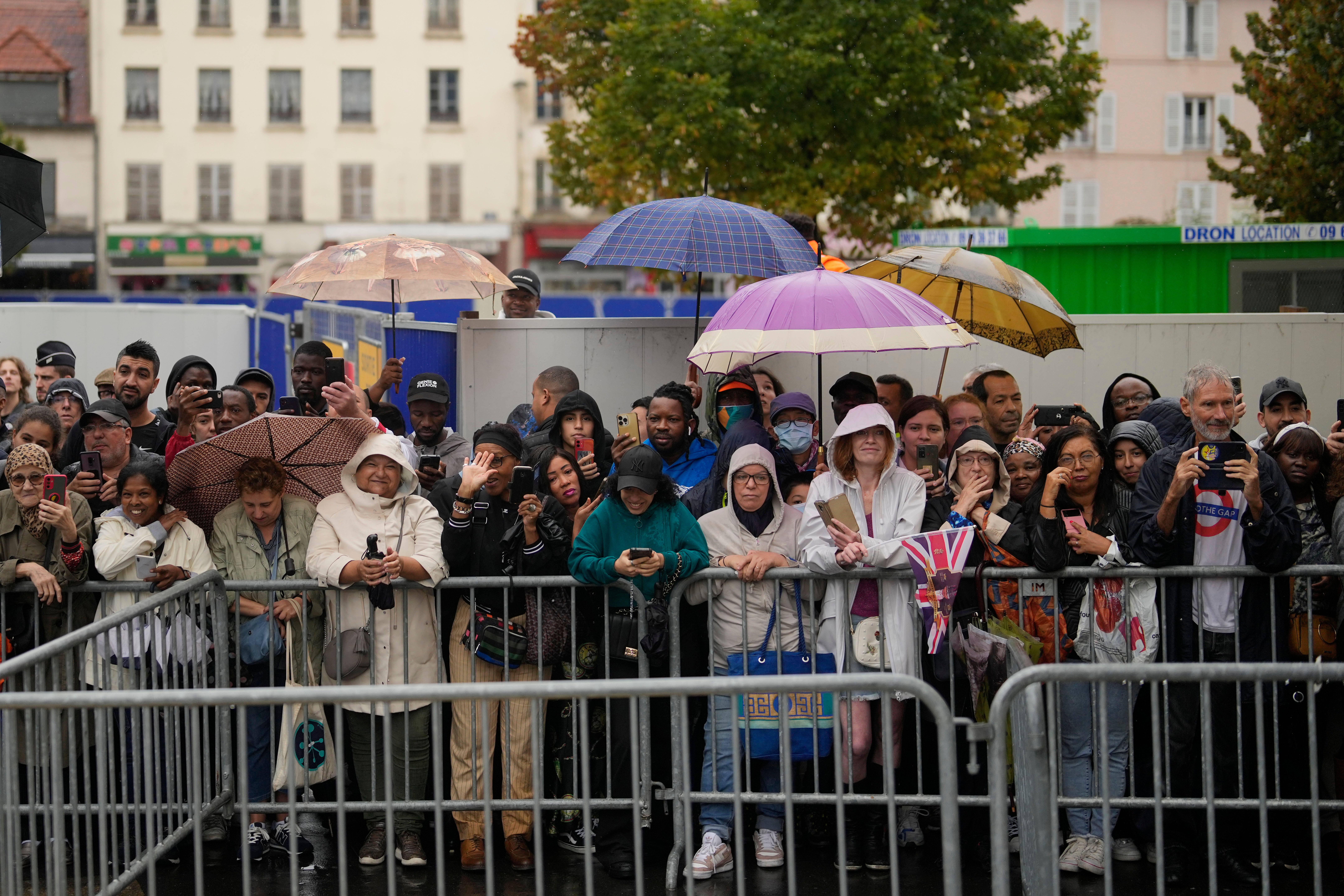 Residents wait to see Charles Camilla on Thursday in Saint-Denis outside Paris