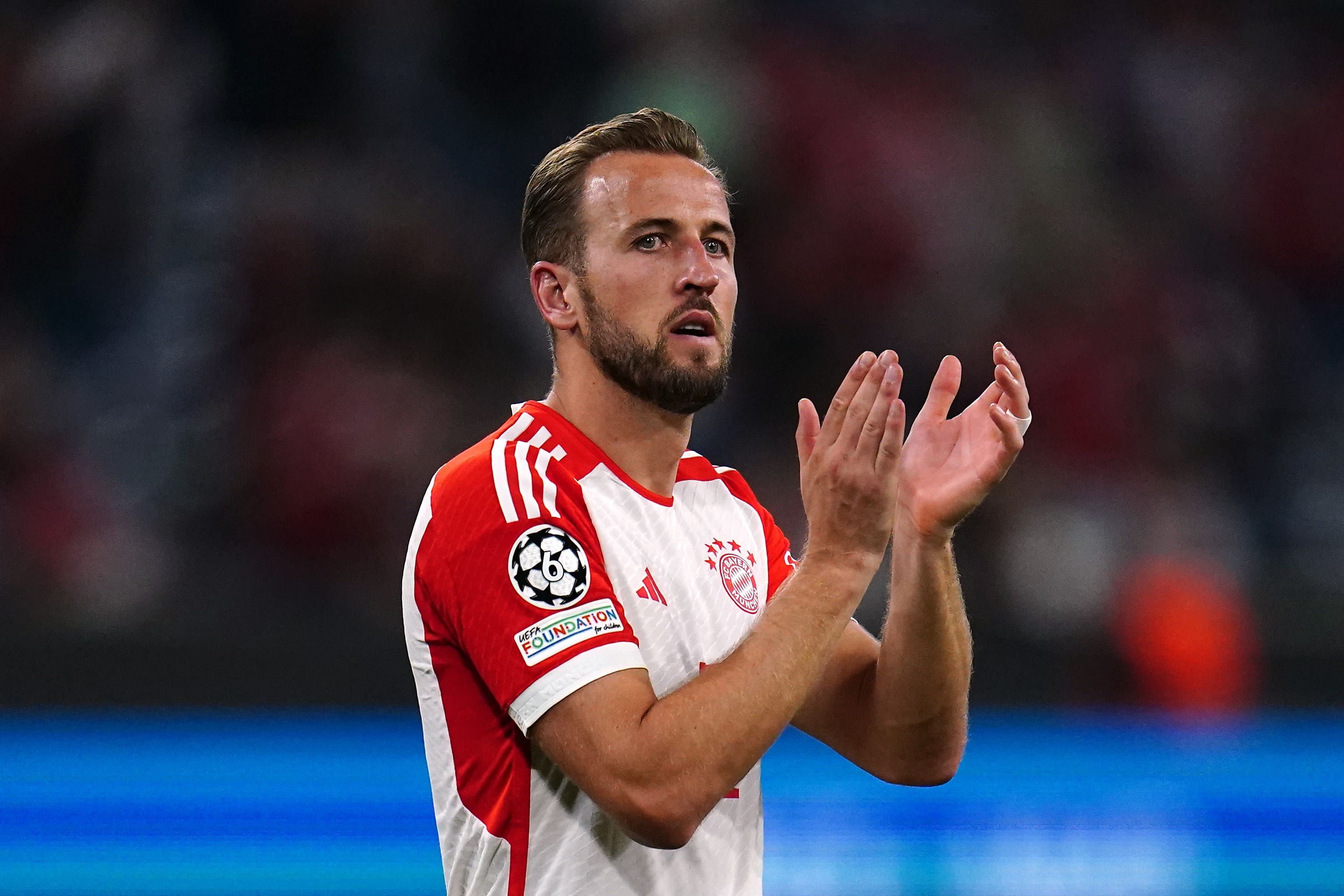  Harry Kane, a player for Bayern Munich, applauds the crowd after a match.