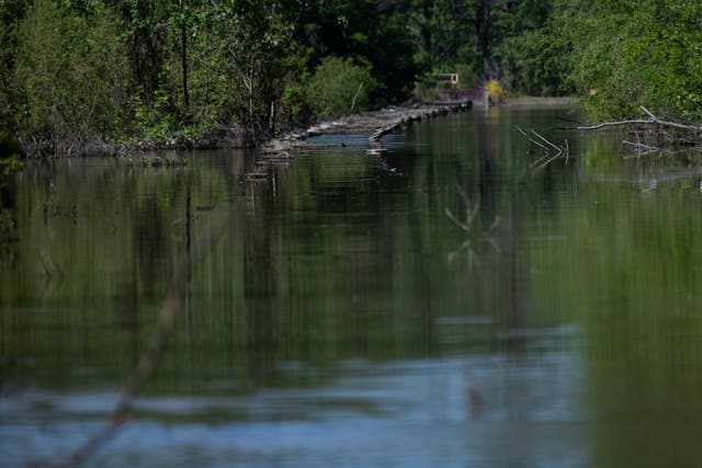 <p>Rail tracks no longer used are seen submerged next to a coal ash storage site, underwater, close to the the BASF and Olin chemical plants  on the Tombigbee River in McIntosh, Alabama on April 12, 2021</p>