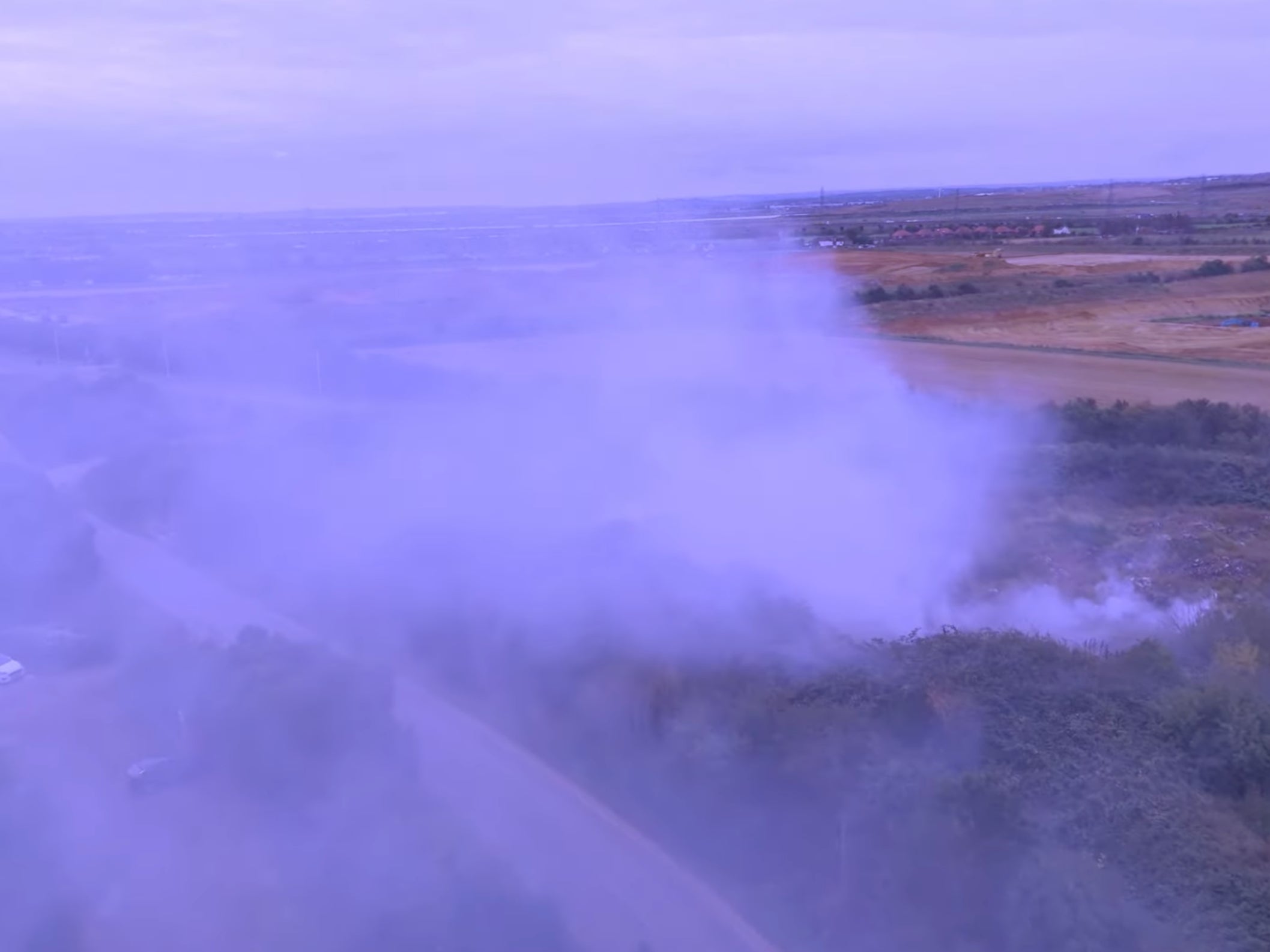 Smoke pours out of the underground fire on the site which has been used as an illegal dump for decades