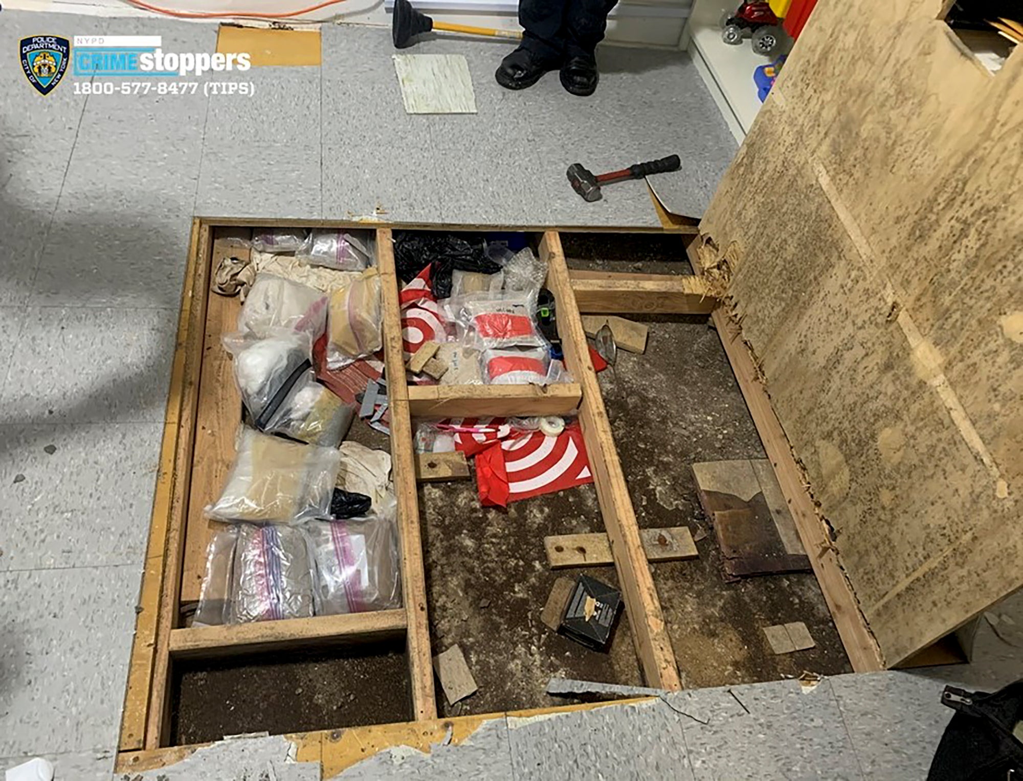 <p>A trap door leans open over narcotics, including fentanyl, and drug paraphernalia stored in the floor of a day care centre</p>