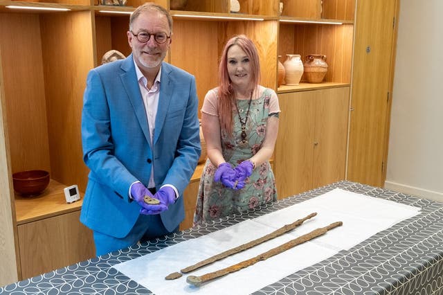 <p>Councillor Paul Hodgkinson from Cotswolds and Emma Stuart, Corinium museum director seen in a photo with the rare Roman swords</p>