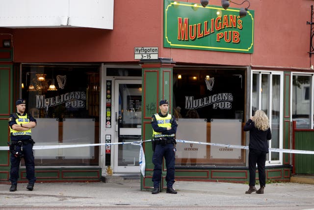 <p>Police stand outside a pub where two people were killed and two wounded following a shooting, in Sandviken</p>