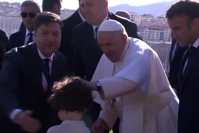 <p>Pope Francis blesses children on visit to Marseille as French President Emmanuel Macron watches on.</p>