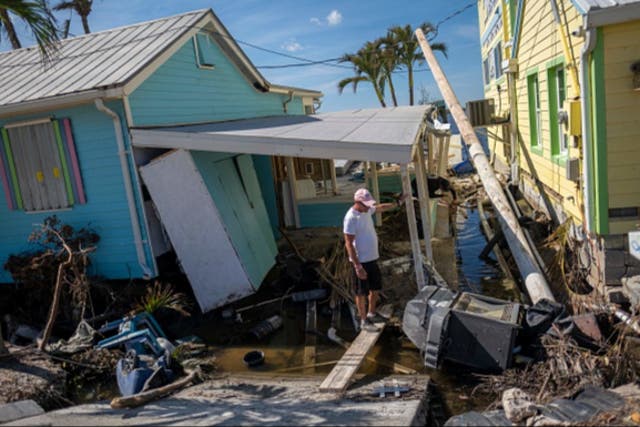 <p>A homeowner surveys Hurricane Ian damage in Florida in September 2022</p>