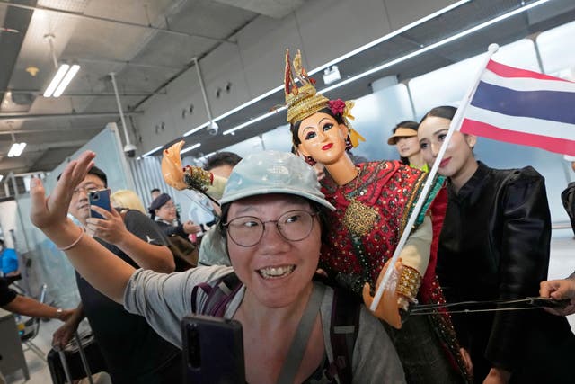 <p>Chinese tourists dance with puppet as Chinese tourists are welcomed on the arrivals at Suvarnabhumi International Airport in Samut Prakarn province, Thailand, Monday, Sept. 25, 2023</p>