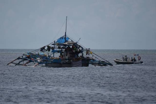 <p>This photo taken on 22 September 2023 shows a Chinese coast guard rigid hull inflatable boat (R) shadowing the Philippine fishing motherboat ‘Moises' (L) as it sailed close to a passage Chinese-controlled Scarborough Shoal in disputed waters of the South China Sea</p>
