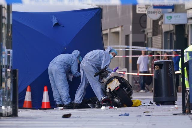 Police forensics officers at the scene of the fatal collision on Tottenham Court Road (Lucy North/PA)