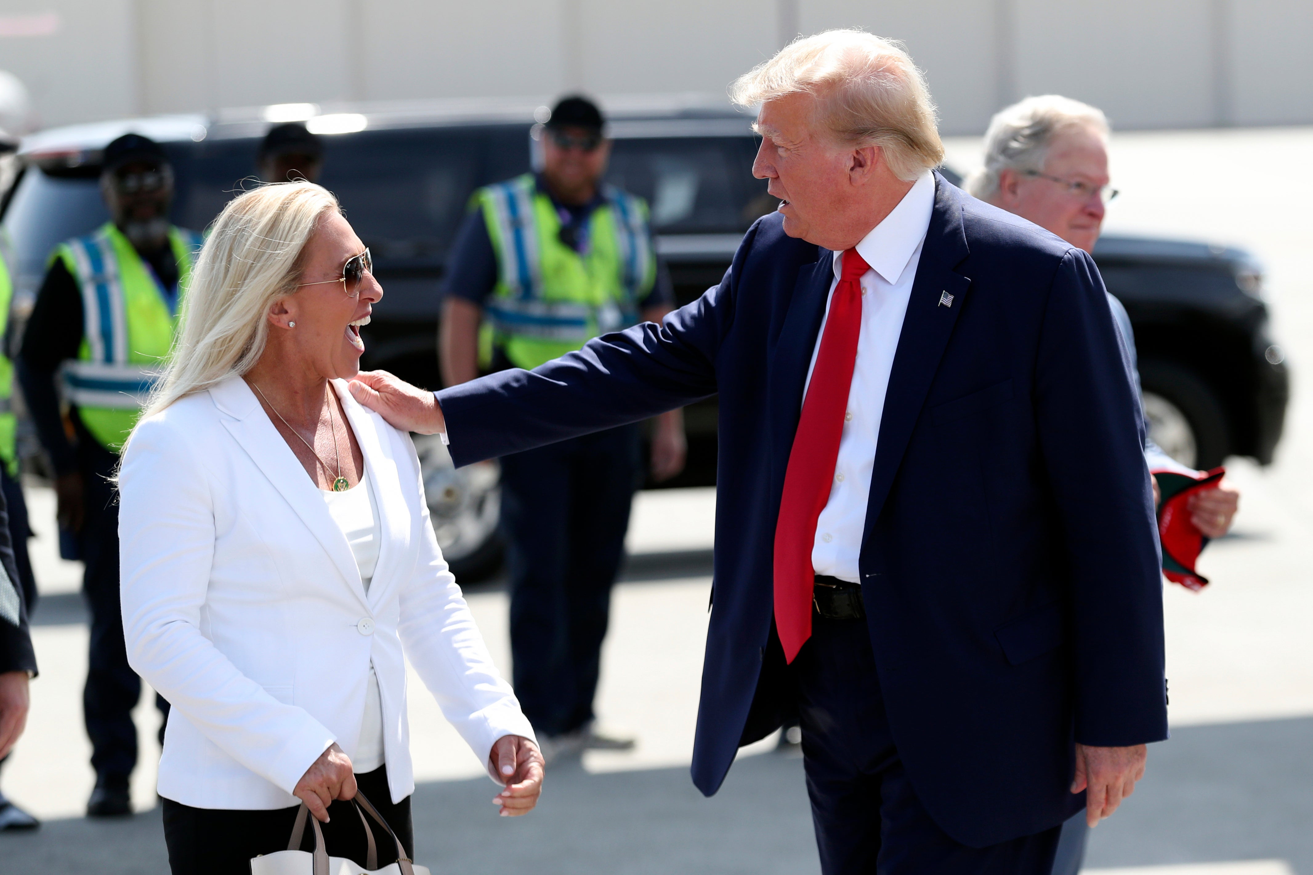 Former President Donald Trump is greeted by Rep. Majorie Taylor Greene, R-Ga., as he arrives at Atlantic Aviation CHS in North Charleston, S.C., Saturday, Sept. 25, 2023