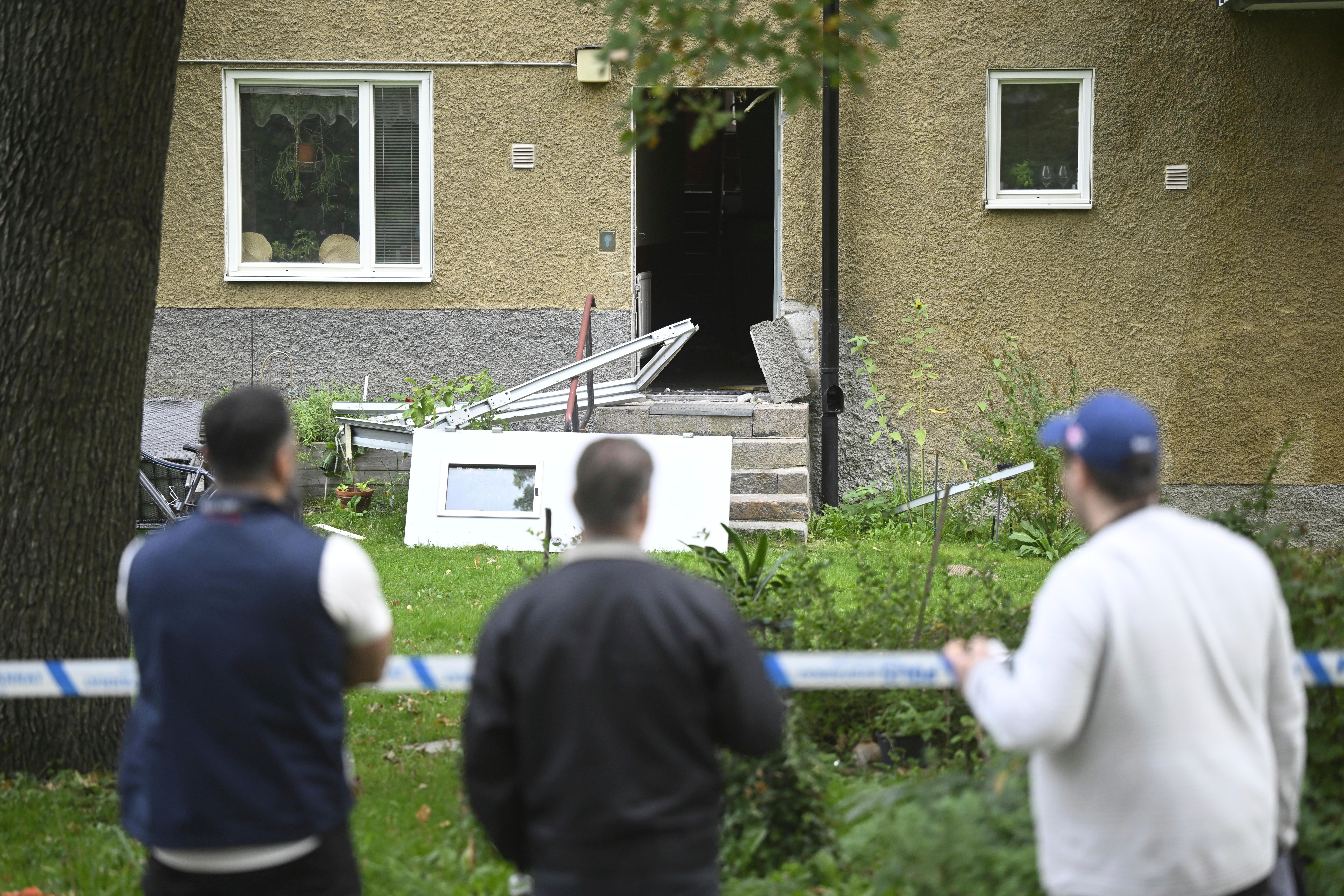 People look at the damage the day after an explosion hit an apartment building in Hässelby, Sweden