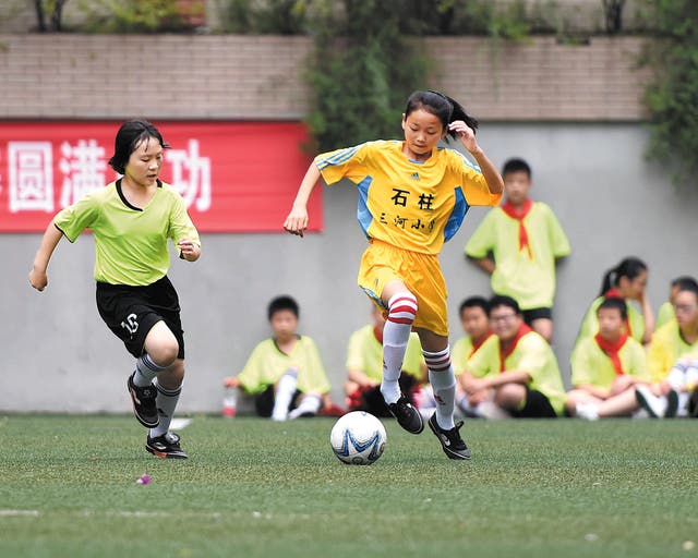 <p>Members of Sanhe Primary School’s girls’ football team in Chongqing’s Shizhu Tujia autonomous county play in an exhibition game</p>