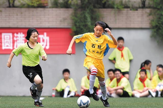 <p>Members of Sanhe Primary School’s girls’ football team in Chongqing’s Shizhu Tujia autonomous county play in an exhibition game</p>